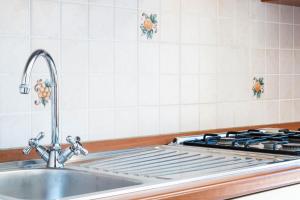 a kitchen counter with a sink and a stove at Appartamenti Cavour H in Villasimius