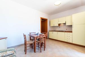 a kitchen and dining room with a table and chairs at Appartamenti Cavour H in Villasimius