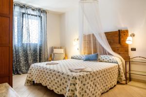 a bedroom with a bed and a window at Villa Glicine - Colleberto in Follonica