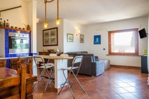 a kitchen and living room with a couch and a table at Villa Glicine - Colleberto in Follonica