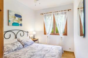 a bedroom with a bed and a window at Can Sito in Cala Tuent