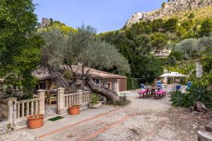 a house with a fence and a table and chairs at Can Sito in Cala Tuent