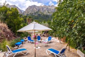 a group of chairs and an umbrella in the sand at Can Sito in Cala Tuent +17 photos