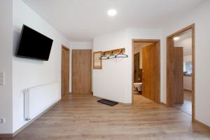 a living room with white walls and a flat screen tv at Ferienwohnungen Übern Hof in Schmallenberg +38 photos