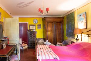 a bedroom with a bed with a pink bedspread at Appartement de charme in Ruoms