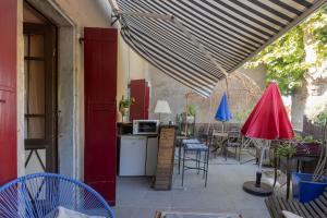 a patio with a table and chairs and an umbrella at Appartement de charme in Ruoms