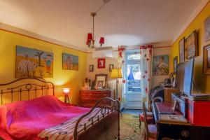 a bedroom with yellow walls and a bed with a red blanket at Appartement de charme in Ruoms