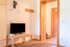 a living room with a television on a table at Sabina Dolomites Zirbel in Alpe di Siusi