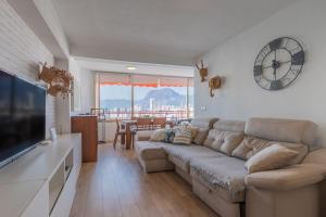 a living room with a couch and a clock on the wall at Don Miguel 2 in Benidorm