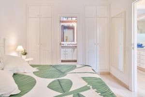 a white bedroom with a green and white bed at Terrazas del Duque Beach Apartment in Adeje +24 photos