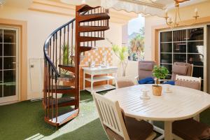 a room with a table and a spiral staircase at Terrazas del Duque Beach Apartment in Adeje