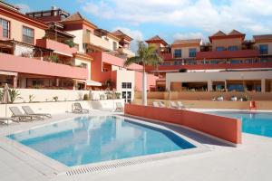 an image of a swimming pool in front of a building at Terrazas del Duque Beach Apartment in Adeje