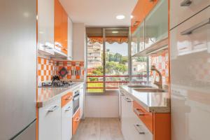a kitchen with orange and white cabinets and a window at Don Miguel 2 in Benidorm