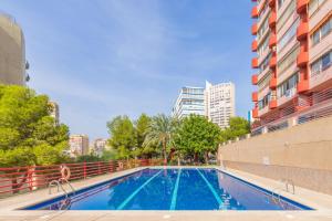 a swimming pool in a city with tall buildings at Don Miguel 2 in Benidorm