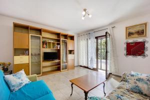 a living room with a blue couch and a table at Casa Taggiasca in Diano Marina