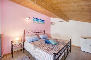 a bedroom with a bed and a wooden ceiling at Casa Taggiasca in Diano Marina