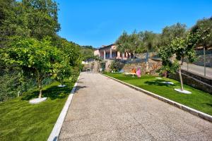 a walkway with trees in a park with a building at Casa Taggiasca in Diano Marina