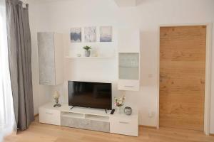 a living room with a television on a white wall at Apartment Serles in Mühlbachl
