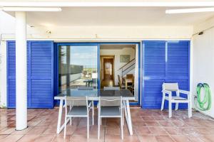 a table and chairs on a patio with blue shutters at Oasis Premium Costa Brava in L'Estartit