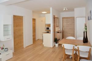 a kitchen and dining room with a wooden table and chairs at Apartment Serles in Mühlbachl