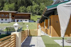 a house with a wooden fence and a building at Apartment Serles in Mühlbachl +17 photos