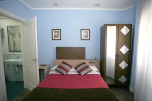 1 dormitorio con 1 cama con 2 almohadas y lavamanos en Pensión Jade, en Castro Urdiales