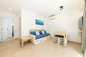 a living room with a blue couch and a table at Apartamento Bon Aire N4 in Cala Ferrera