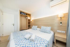 a bedroom with a large bed with blue and white sheets at Apartamento Bon Aire N4 in Cala Ferrera +15 photos