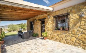 a stone house with a patio and a stone wall at La Cañada in El Gastor