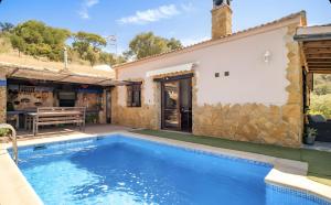 a villa with a swimming pool next to a house at La Cañada in El Gastor
