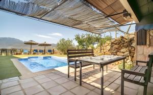 a patio with a table and chairs and a pool at La Cañada in El Gastor +9 photos