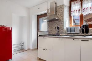 a kitchen with white cabinets and a red refrigerator at La piccola Lami in Intra +14 photos
