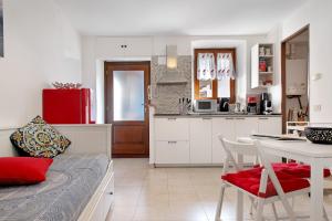 a kitchen with white cabinets and a table with a red pillow at La piccola Lami in Intra