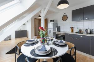 a kitchen and dining room with a white table and chairs at Cityloft für Stilvolle in Dessau