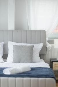 a white bed with a blue blanket on top of it at Cityloft für Stilvolle in Dessau