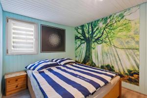 a bedroom with a large tree mural on the wall at Ferienhaus 219 in Zadelsdorf