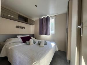 a bedroom with a large white bed with towels on it at Coral Bungalow in Ayamonte