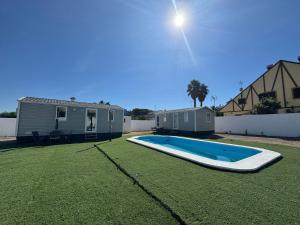 a swimming pool in a yard next to a house at Coral Bungalow in Ayamonte