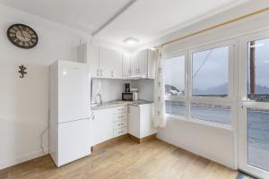 a kitchen with white cabinets and a large window at Casa Lea Artenara in Artenara