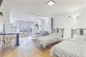 a bedroom with two beds and a table and a desk at Casa Lea Artenara in Artenara
