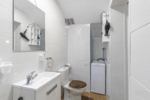 a white bathroom with a toilet and a sink at Casa Lea Artenara in Artenara +26 photos