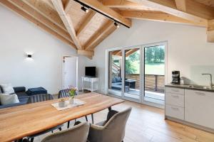 a kitchen and living room with a wooden table and chairs at Ferienwohnung Schwaiger Almblick in Bad Tölz