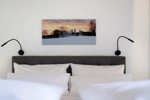 a bed with two white pillows and two lights above it at Ferienwohnung Schwaiger Almblick in Bad Tölz