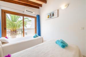 two beds in a room with a window at Apartamento Poseidonia in Felanitx +18 photos