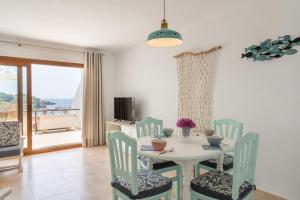 a dining room with a table and chairs with a view at Apartamento Poseidonia in Felanitx
