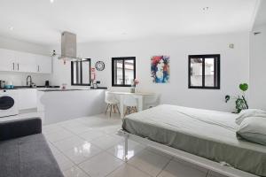 a white room with a bed and a kitchen at Mi Casa Es Su Casa Nº4 in Albufeira