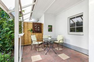 a patio with a table and chairs and a window at Ferienwohnung zur Ostsee in Westerholz