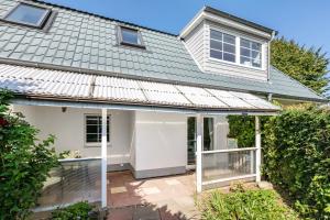 a white house with a roof and a patio at Ferienwohnung zur Ostsee in Westerholz