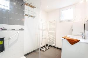 a white bathroom with a shower and a sink at Maison Boyardville Piscine in Saint-Georges-dʼOléron +12 photos