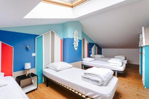 three beds in a room with blue walls at Maison Boyardville Piscine in Saint-Georges-dʼOléron
